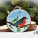 A handcrafted wood slice Christmas ornament with a handpainted bird at Cove Creek Photography.